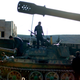 Syrian fighters stand on a tank captured during a raid on a military base near Aleppo, 2012.